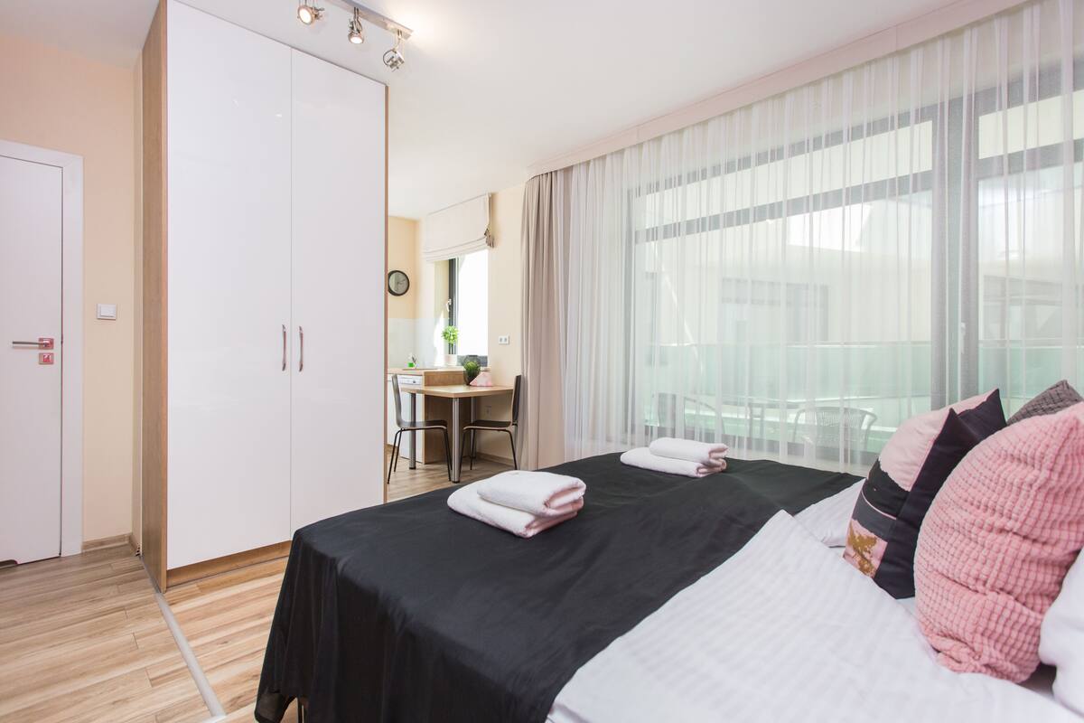 A hotel room with a bed, a desk, and a wardrobe.