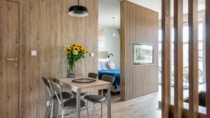 Una cocina moderna con una pared de madera, una mesa de comedor con sillas y un jarrón de girasoles.