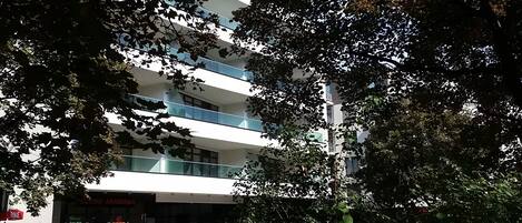 A multi-story building with a modern design, featuring balconies and large windows.
