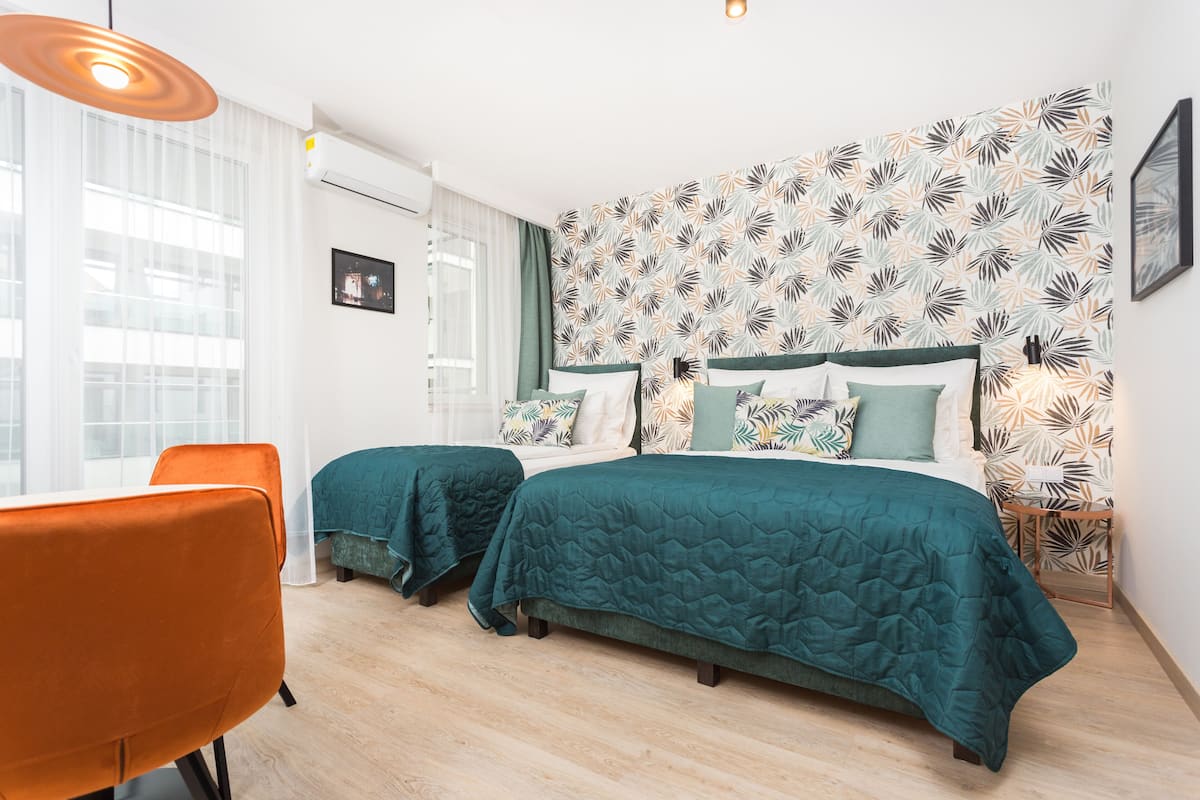 A hotel room with two beds, a desk, and a chair.