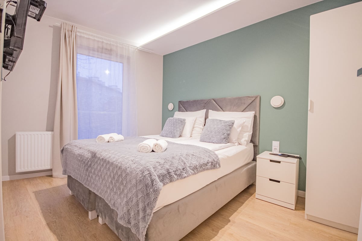 A bedroom with a bed, bedside table, and a wardrobe.
