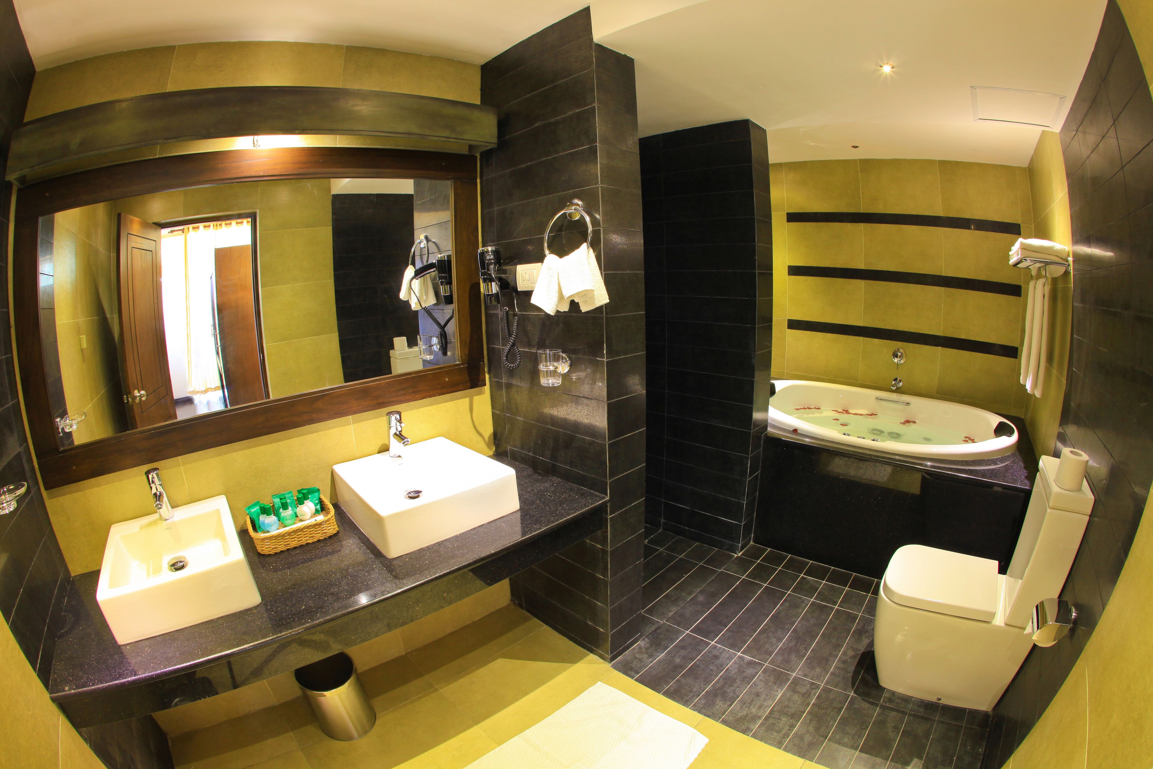 Ein modernes Badezimmer mit zwei Waschbecken, einem großen Spiegel, einer Badewanne und einer Toilette.