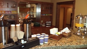 A coffee station with a coffee machine, cups, and a sign indicating 'Coffee'. - Lakeside Motor Inn (Gladstone)