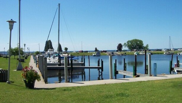 A marina with boats docked, a grassy area, and a clear sky. - Lakeside Motor Inn (Gladstone)