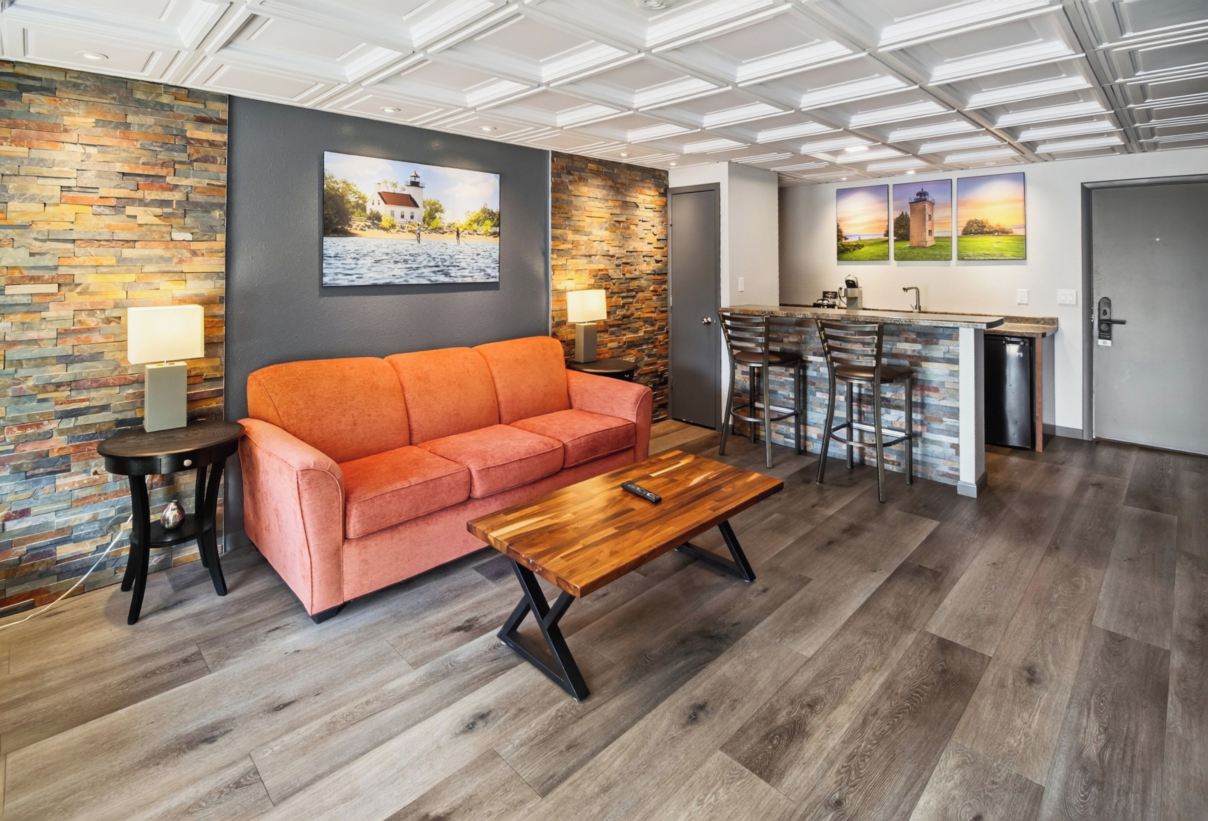 A modern living room with a sofa, a coffee table, and a kitchen area with a bar.