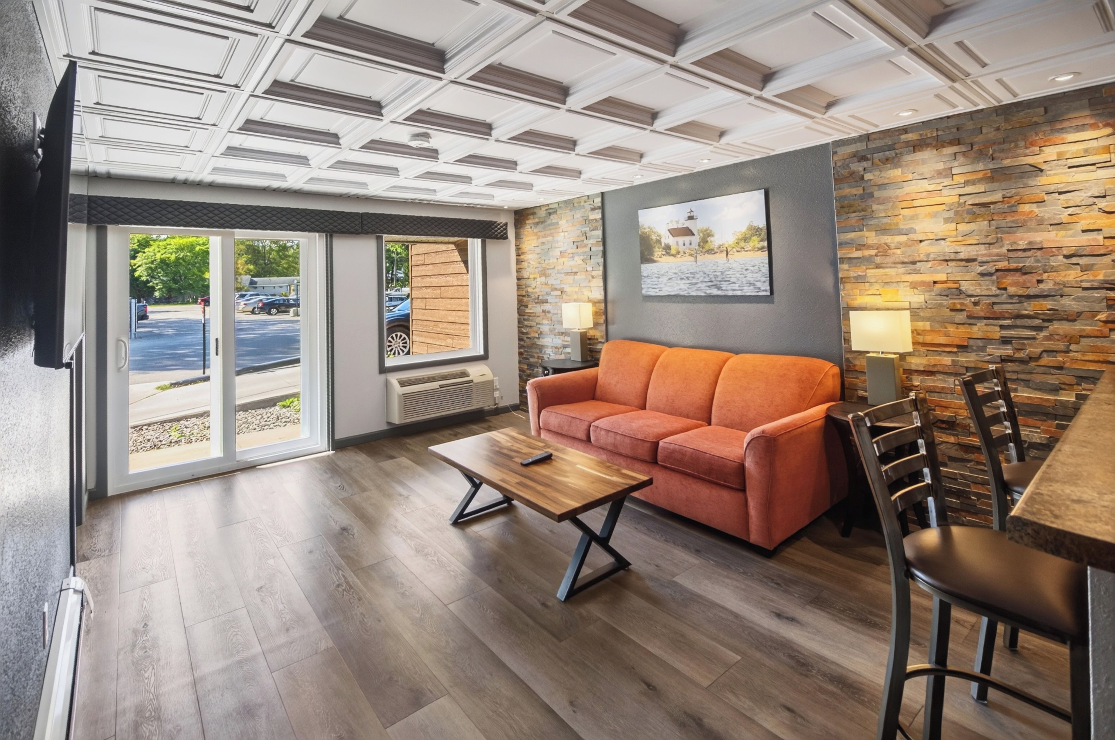 A modern interior with a sofa, a coffee table, and a stone accent wall.