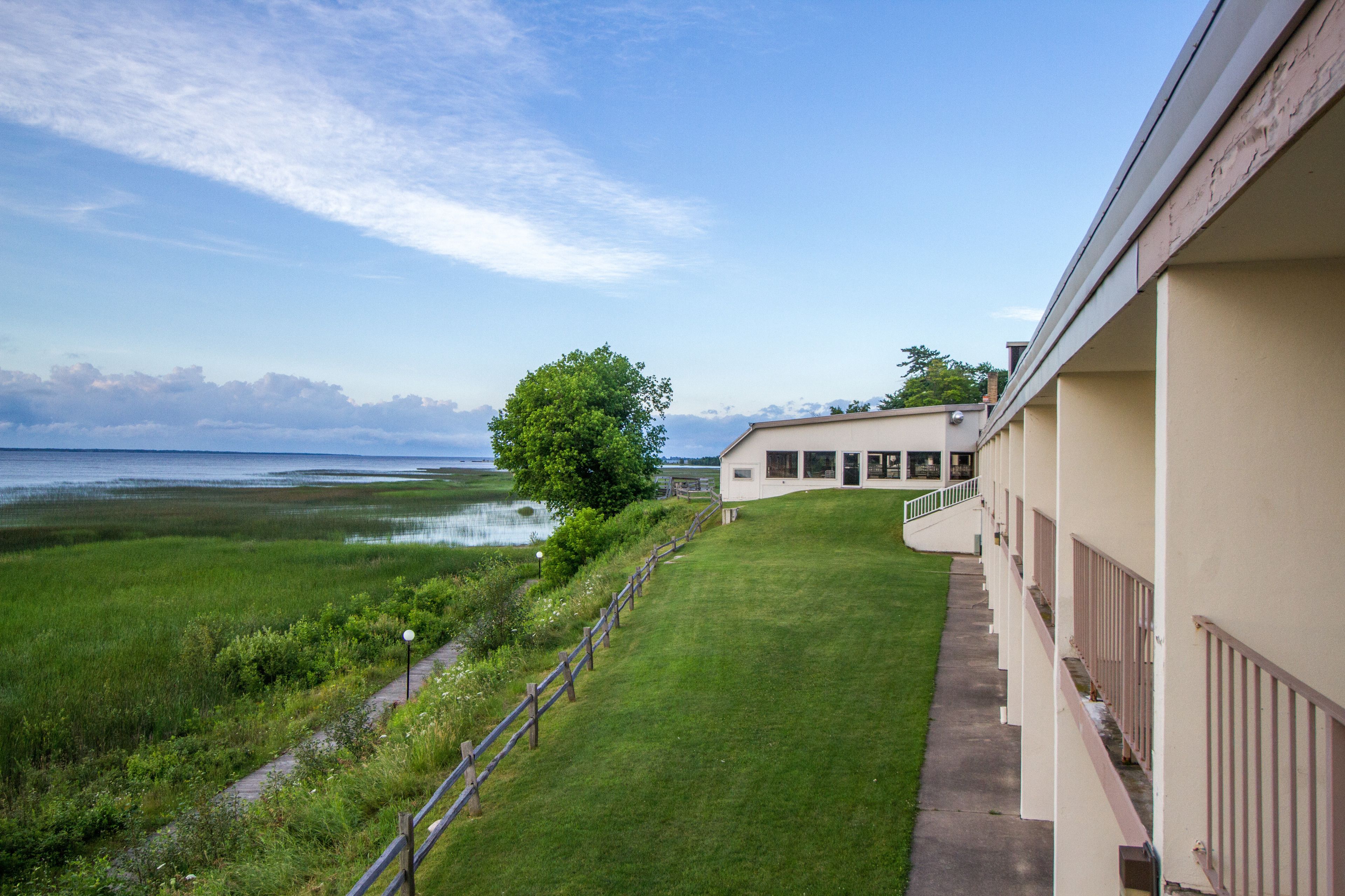 A building with a view of a grassy area and a body of water.