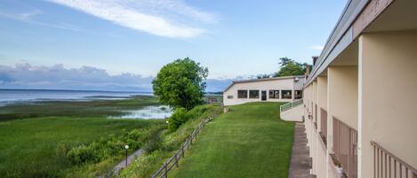 A building with a view of a grassy area and a body of water.
