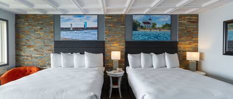 A hotel room with two beds, a brick accent wall, and a view of a lighthouse and beach.
