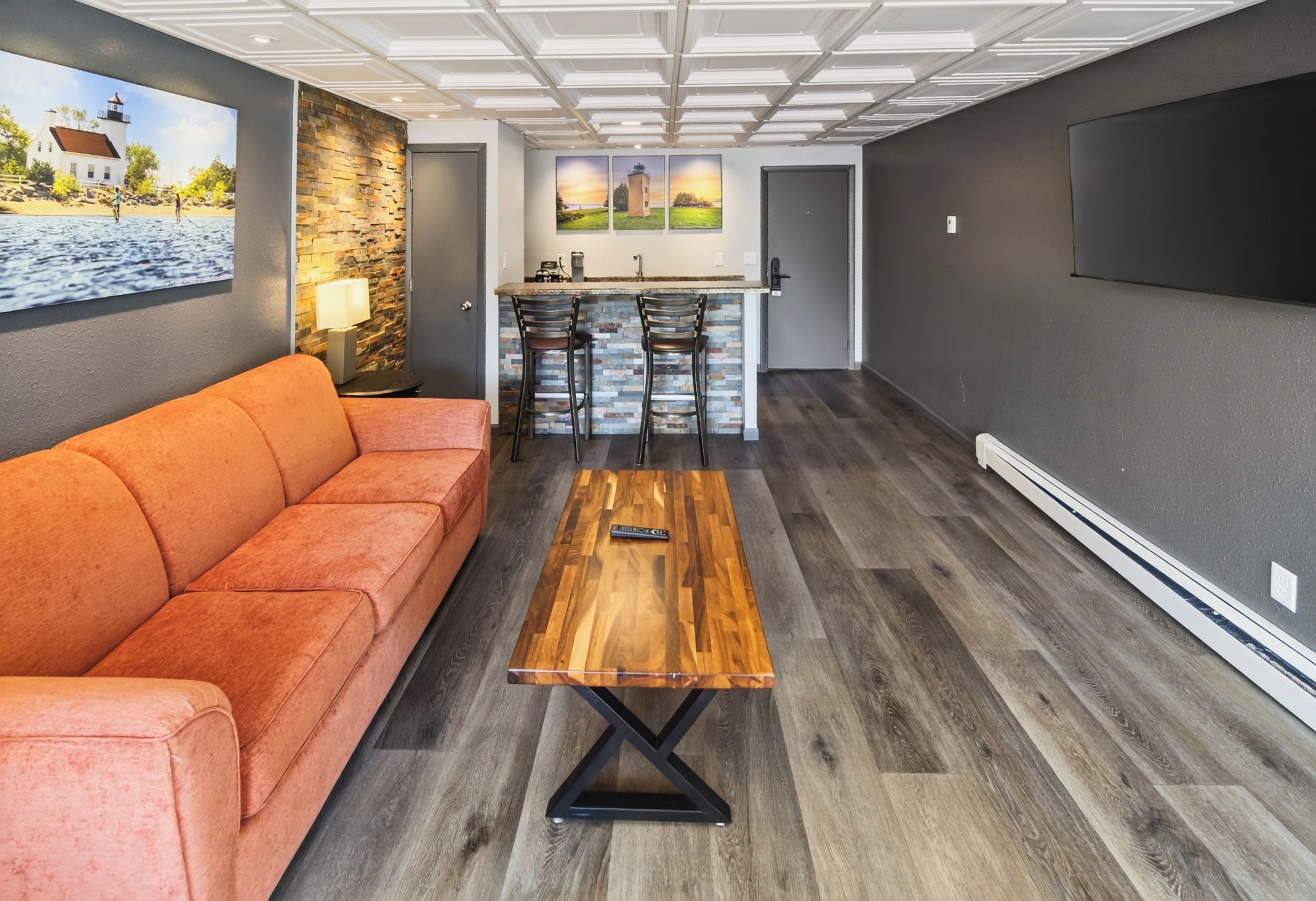 Een moderne woonkamer met een bank, salontafel en een keukenbar.