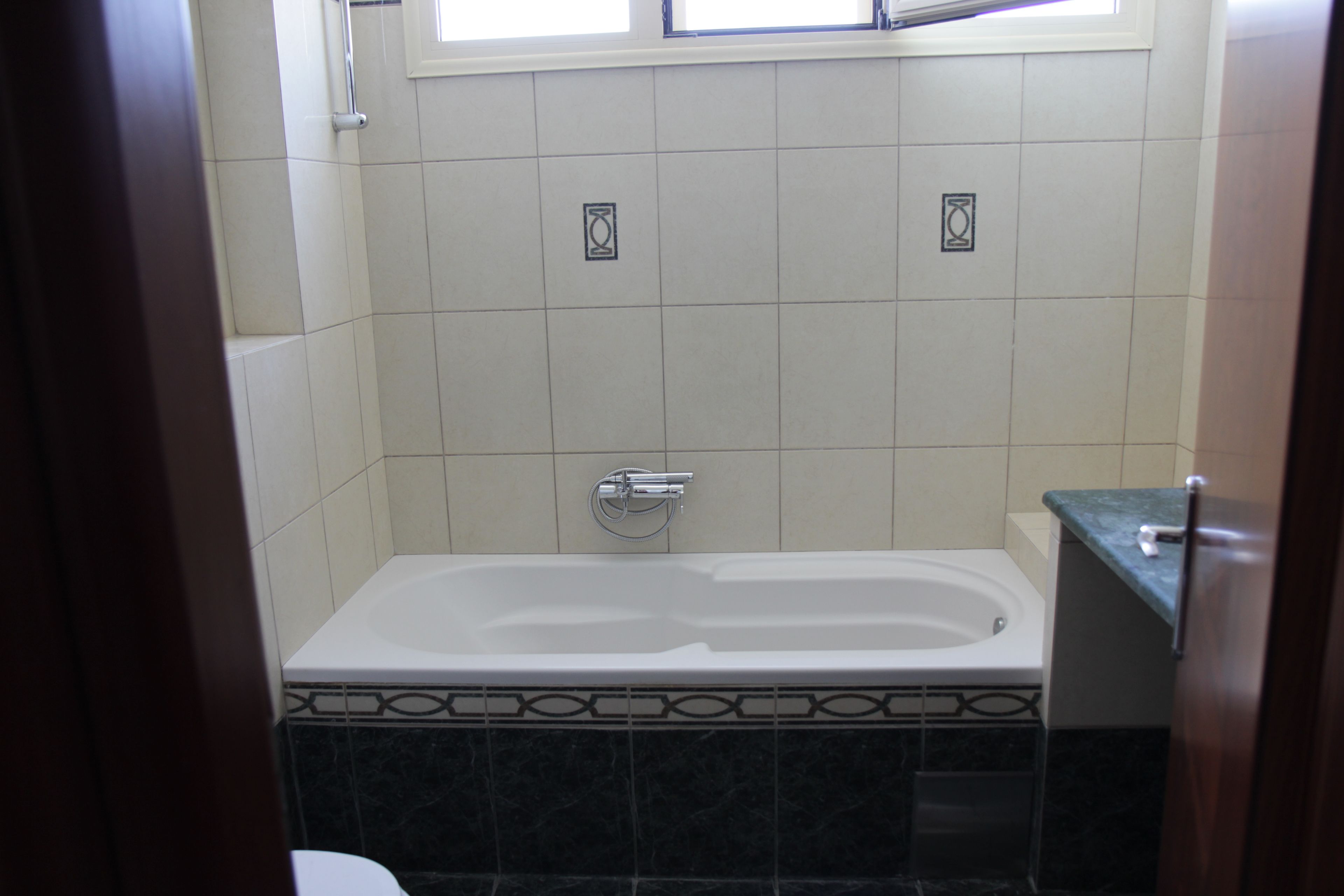 Een badkamer met een bad, toilet en douche.