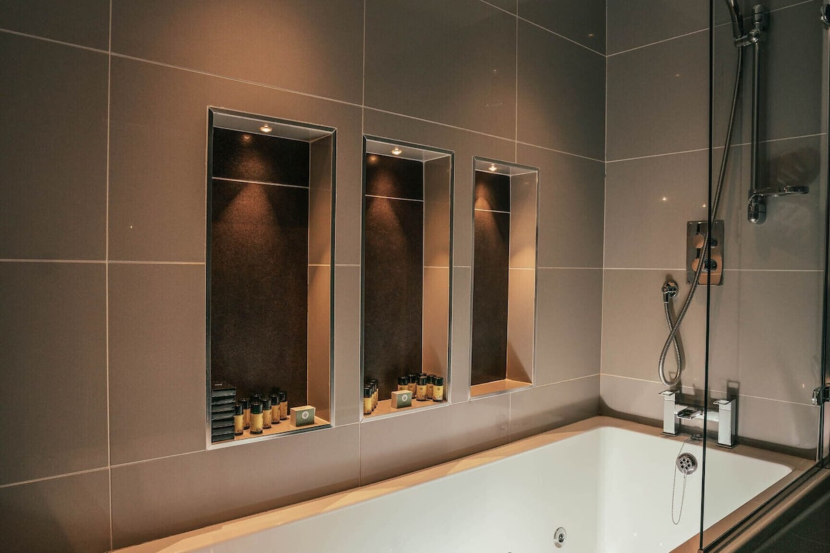 combined shower/bathtub, designer toiletries, towels