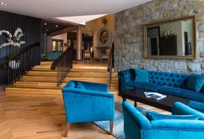 Amplia sala de estar con escaleras, una pared de piedra y un espejo grande.