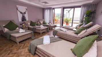 A hotel room with two beds, a balcony, and a view of the outdoors.