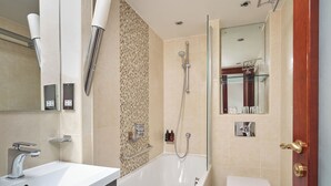 A modern bathroom with a bathtub, toilet, and sink. - The Prime London Hotel (London)