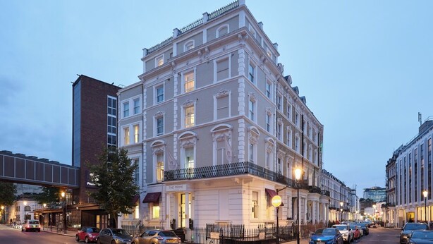 A multi-story building with a classic architectural style, featuring a prominent entrance and a balcony. - The Prime London Hotel (London)