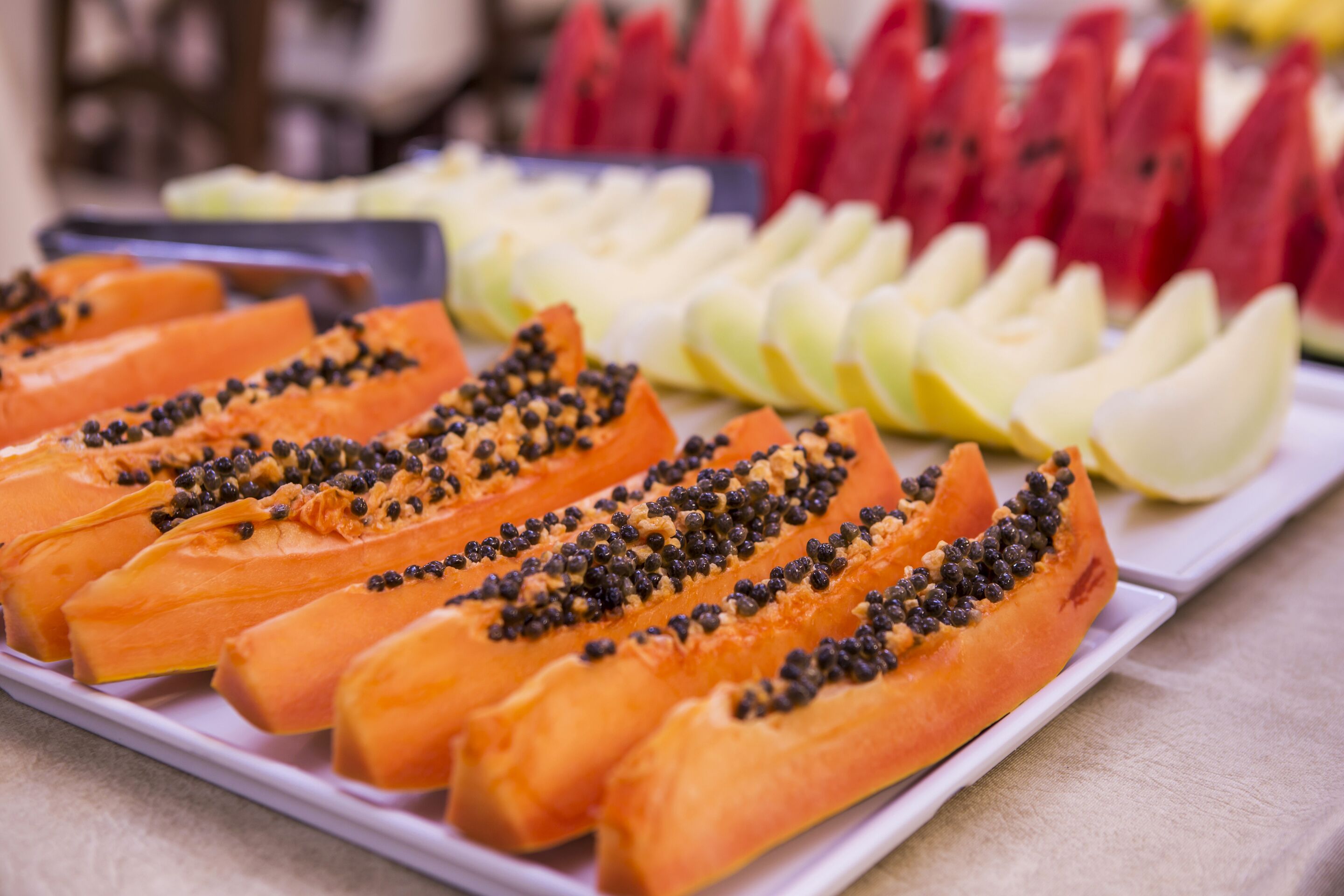 Diversas frutas, como papaya y sandía, sobre una bandeja.