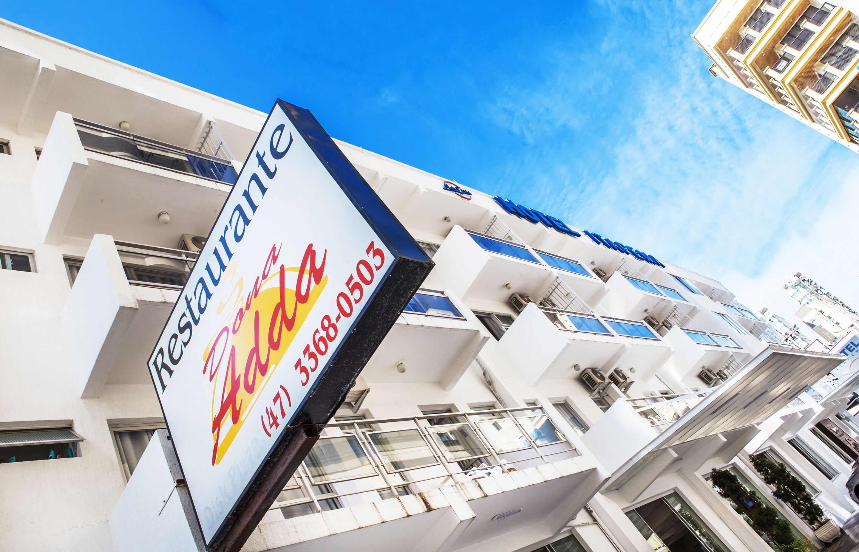 A multi-story building with balconies and a sign for a restaurant named "Restaurant Addo".