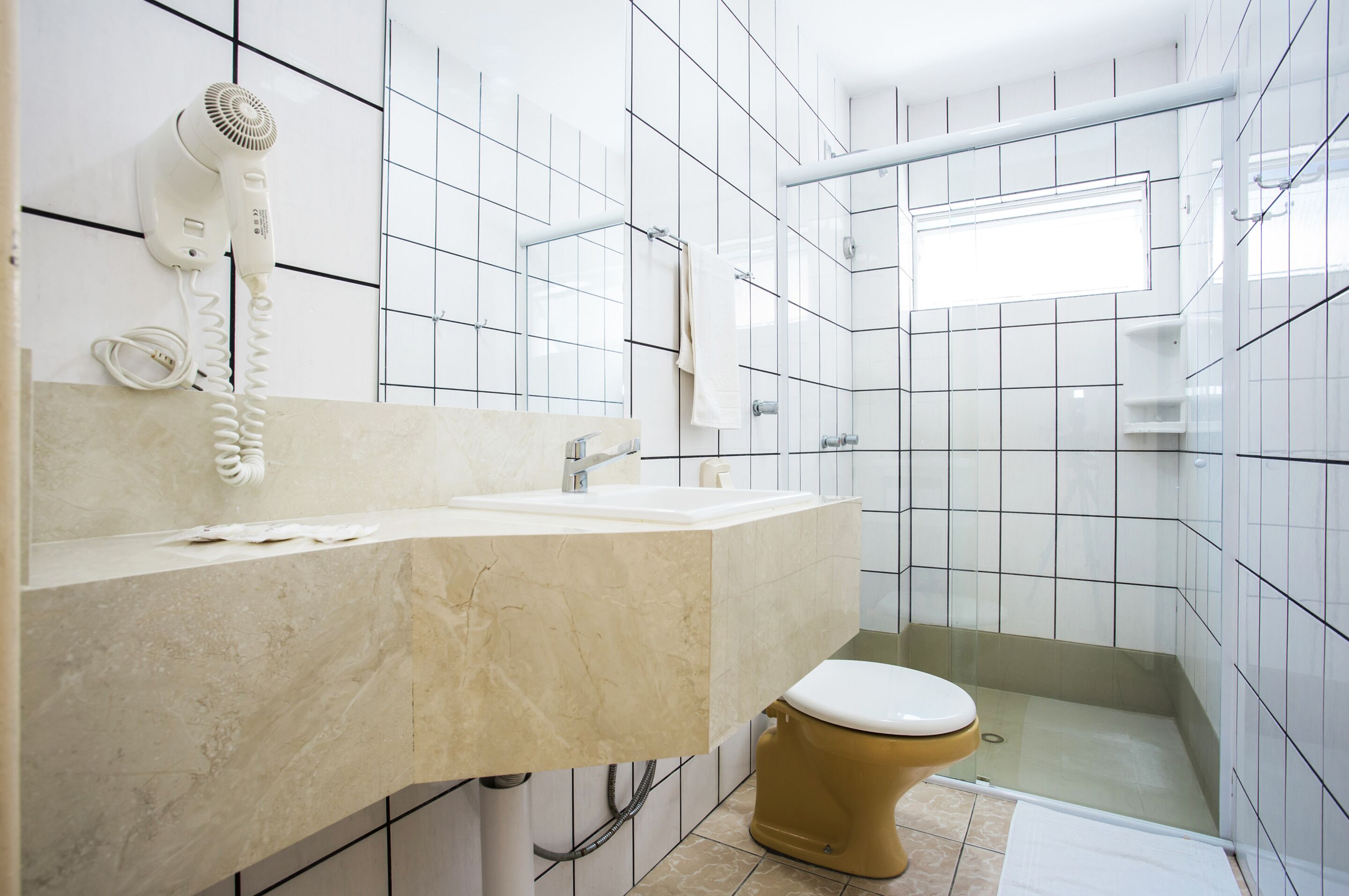 A bathroom with a white sink, a toilet, and a shower area.