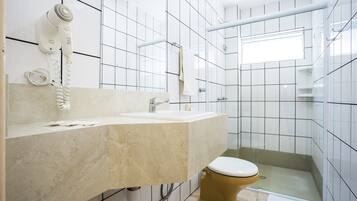 A bathroom with a white sink, a toilet, and a shower area.