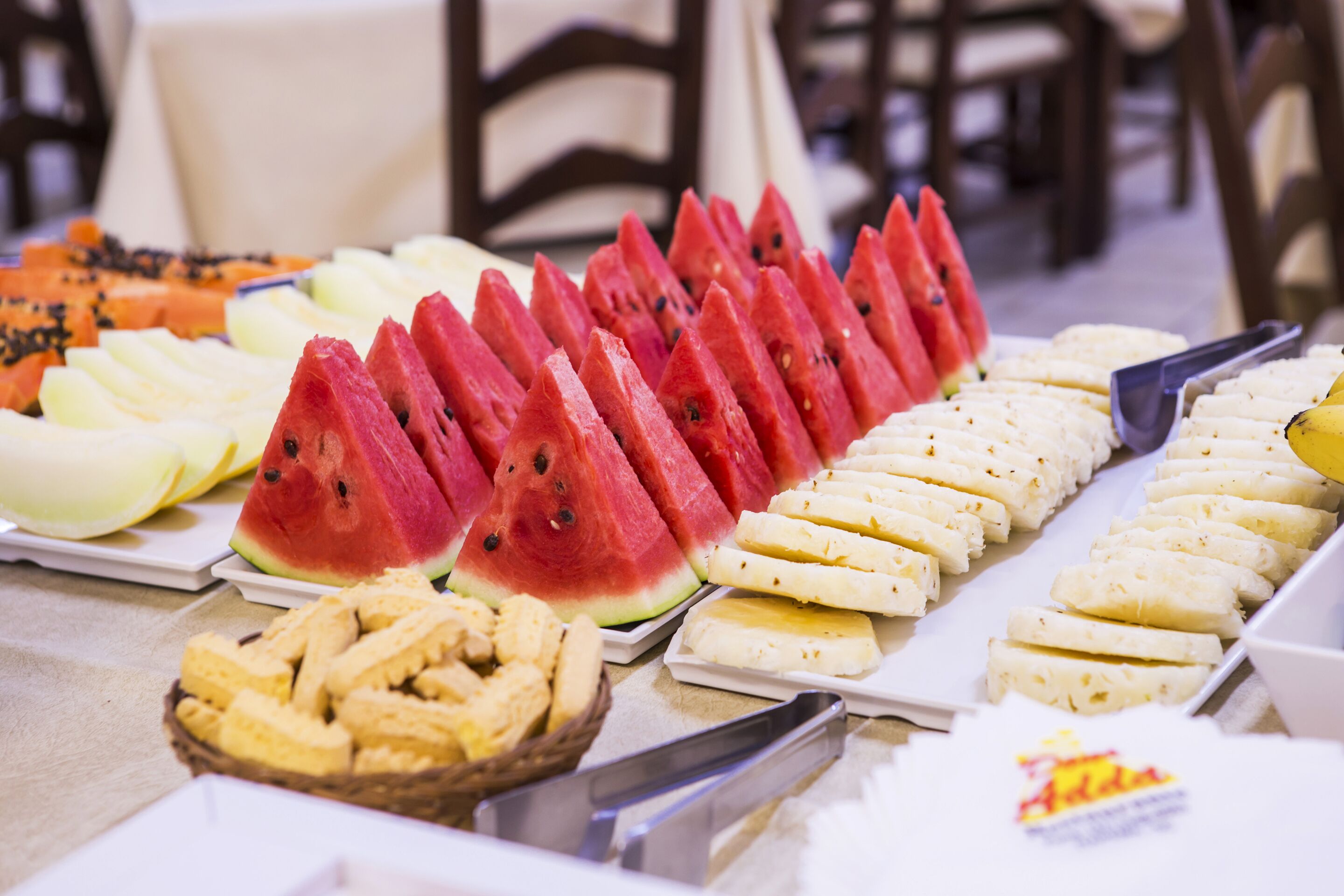 A buffet table with various fruits and pastries.