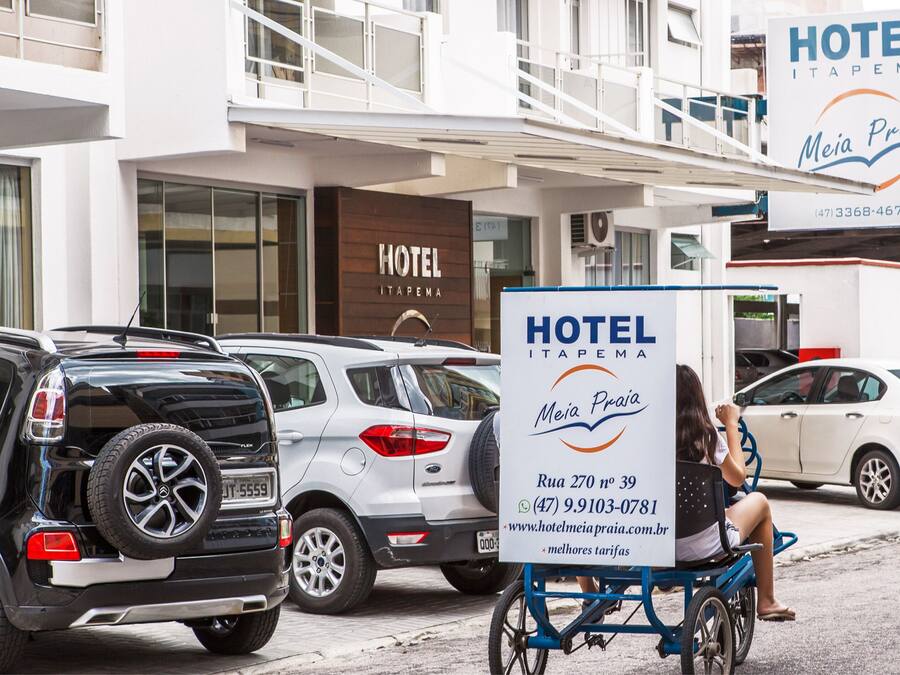 Un hotel llamado "Hotel Itapema" con un cartel que muestra su nombre e información de contacto.