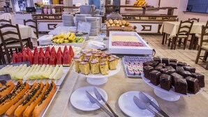Un bufé con diversos alimentos, entre ellos frutas, pastelería y postres.