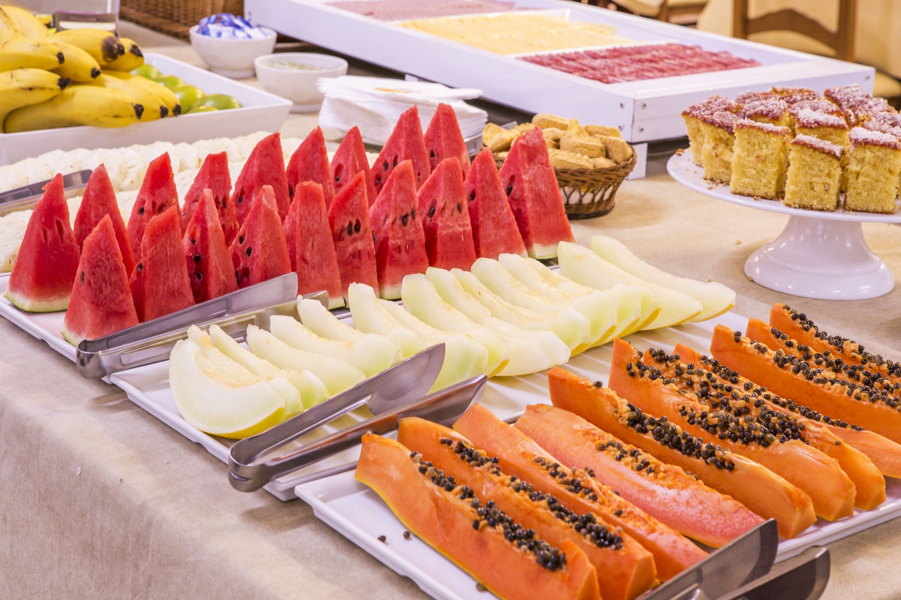 A buffet with various fruits and desserts.