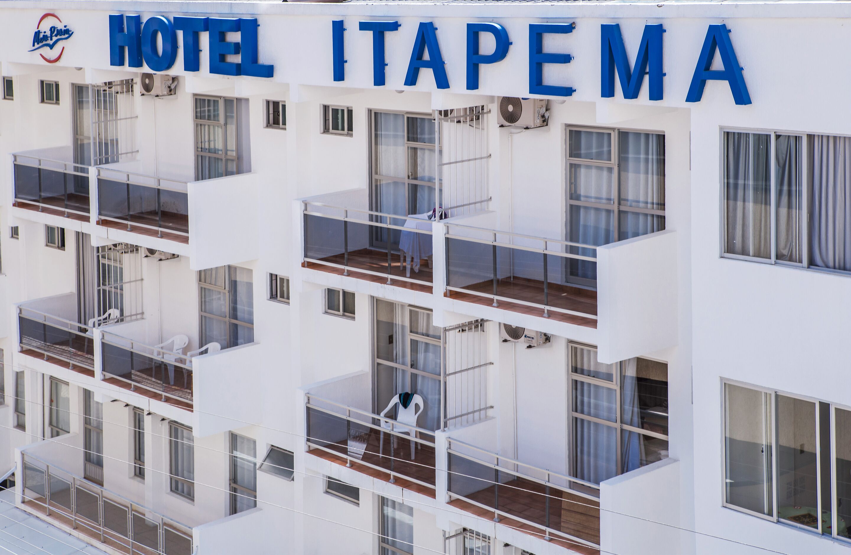 A multi-story hotel with balconies and a sign reading "HOTEL ITAPEMA".