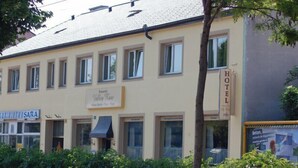 A hotel building with a sign indicating it is a hotel. There are multiple windows on the facade, and the building has a flat roof. - Hotel - Restaurant Valley Rose (Vienna)