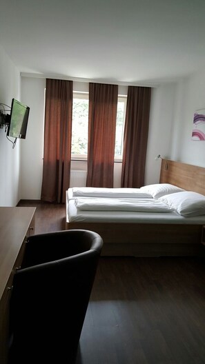 A hotel room with a bed, a desk, a chair, and a television. - Hotel - Restaurant Valley Rose (Vienna)