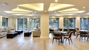 Una habitación amplia, luminosa, con muebles modernos, ventanas grandes y un diseño de techo singular.