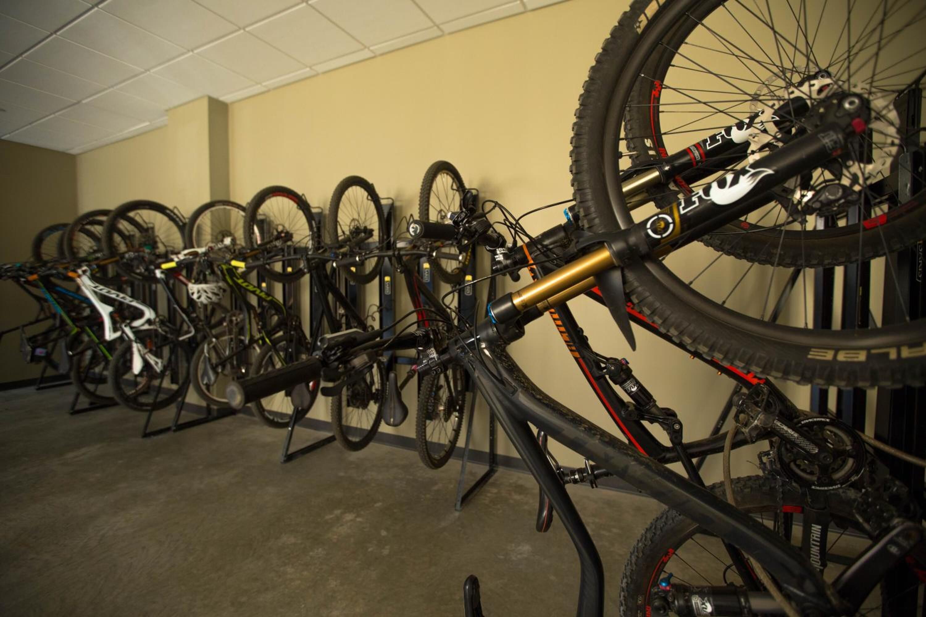 Uma área de armazenamento para bicicletas com várias bicicletas presas em suportes.