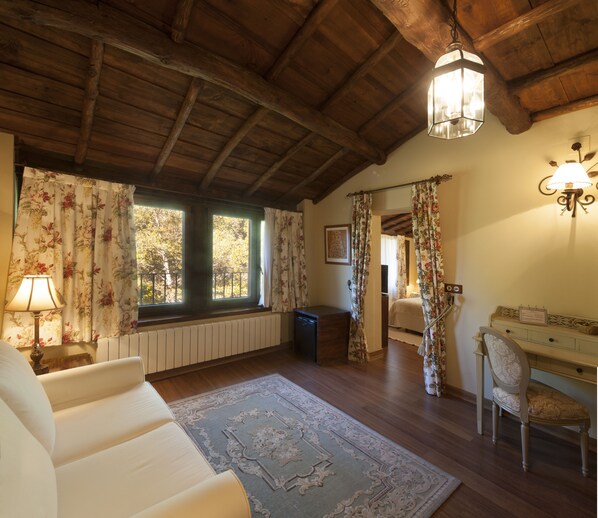 Una habitación acogedora con vigas de madera, una cama, un escritorio y una silla.