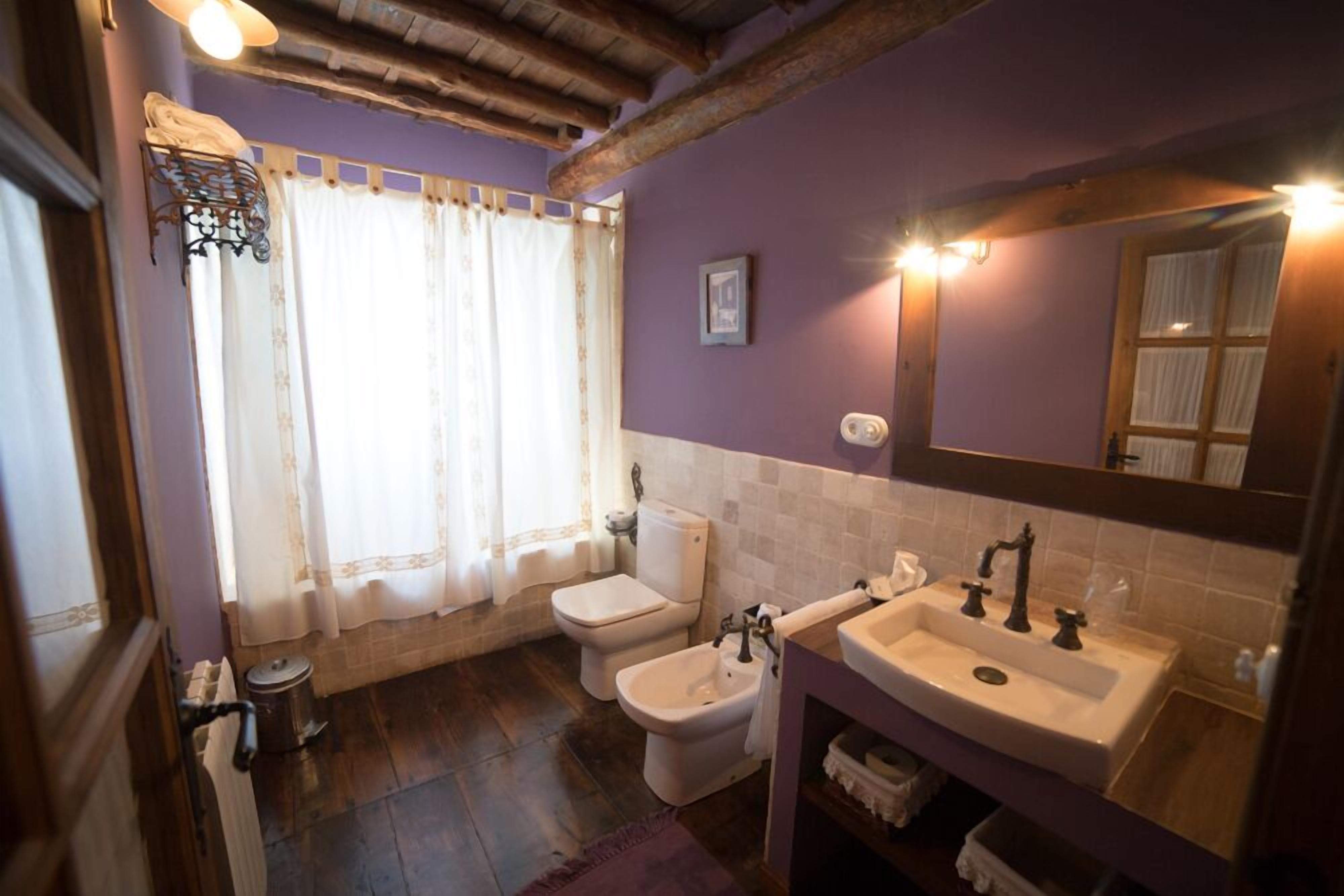 Un baño con inodoro, lavabo, espejo y bidé.