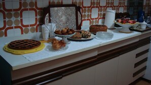 A buffet table with various baked goods and a coffee machine.