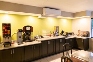 Cocina moderna con estación de café, microondas, tostadora y un ventanal grande.