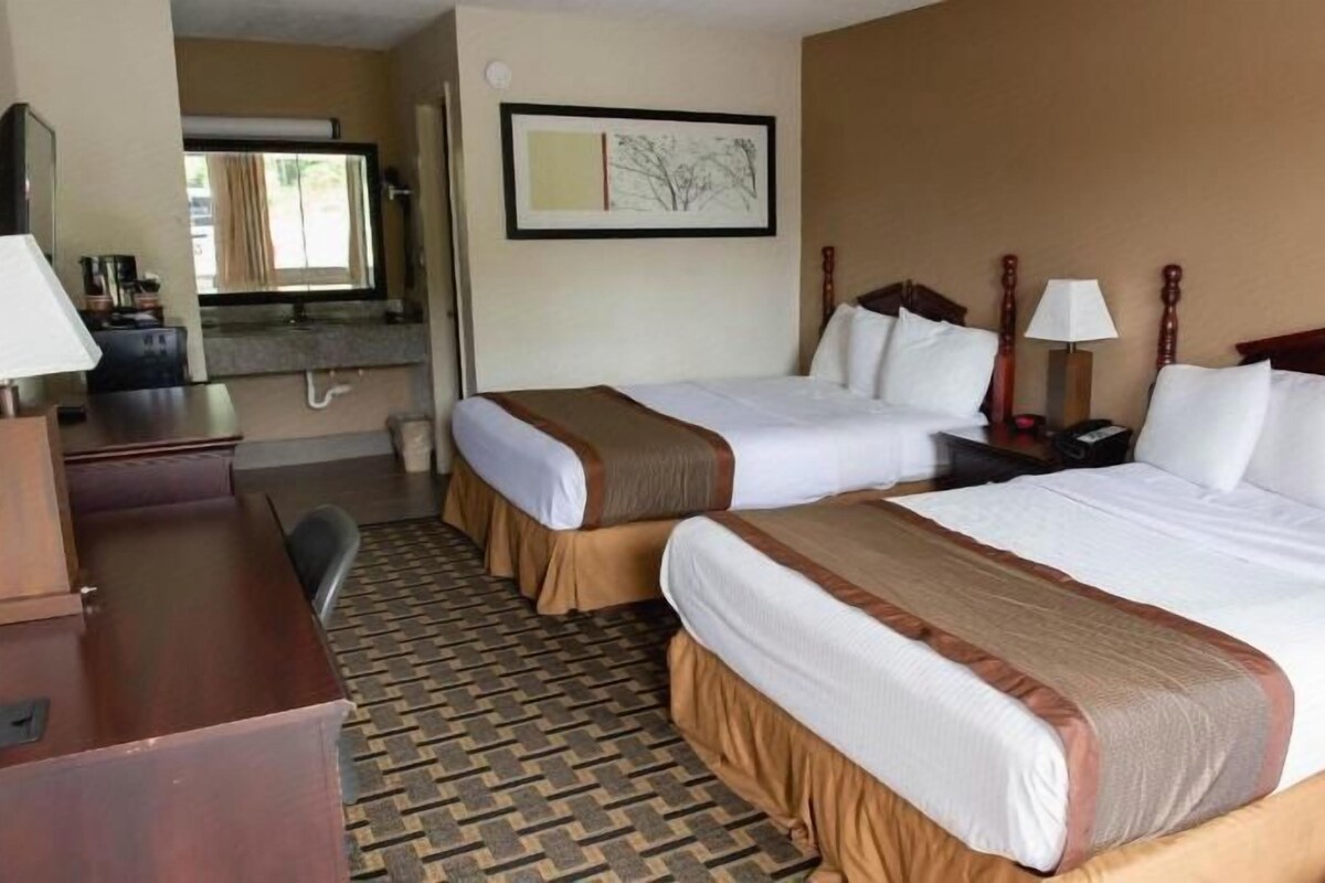 Une chambre d’hôtel avec deux lits, un bureau et une chaise.