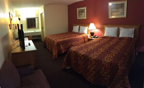Une chambre d’hôtel avec deux lits, un bureau, une chaise, une télévision et une lampe.
