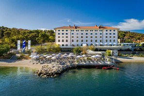 Un grand hôtel doté d’une cour intérieure, d’un espace extérieur aménagé pour s’asseoir et d’un quai.