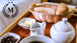 A tray with a cup of coffee, a jug, a small bowl of condiments, and a basket of bread. - Musky Hs & Suites (Chiclayo)