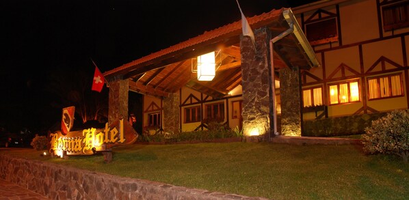 A traditional building with stone pillars and a tiled roof, illuminated by warm lighting. - Berna Hotel & Spa (Villa General Belgrano)