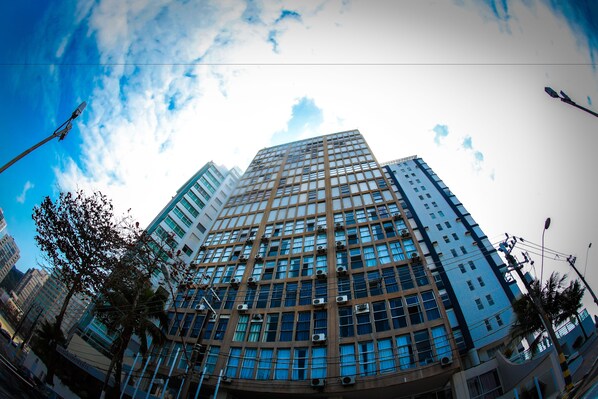 Standing tall in the city, this high-rise building offers stunning views from its grid of windows.
