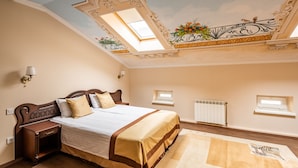 A bedroom with a large bed, wooden headboard, two bedside tables, a skylight, and a decorative ceiling. - Guest House Inn Lviv (Lviv)