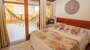 A bedroom with a bed, a hammock, and a view of the outside. - Pousada Funny (Morro de Sao Paulo)