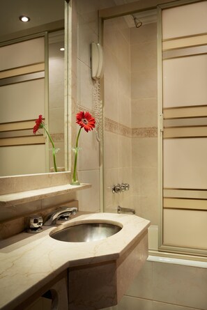 A bathroom with a sink, mirror, and shower. - Gran Hotel Ailen (Buenos Aires)