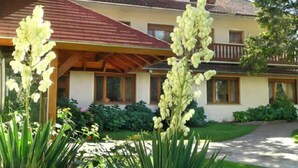 Una casa a due piani con un portico coperto e un giardino curato.