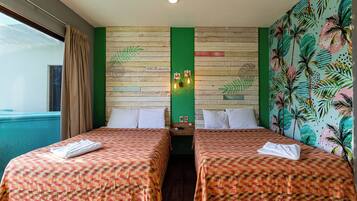 A hotel room with two beds, a green wall with a palm leaf pattern, and a sign that reads 'All Riviera'.