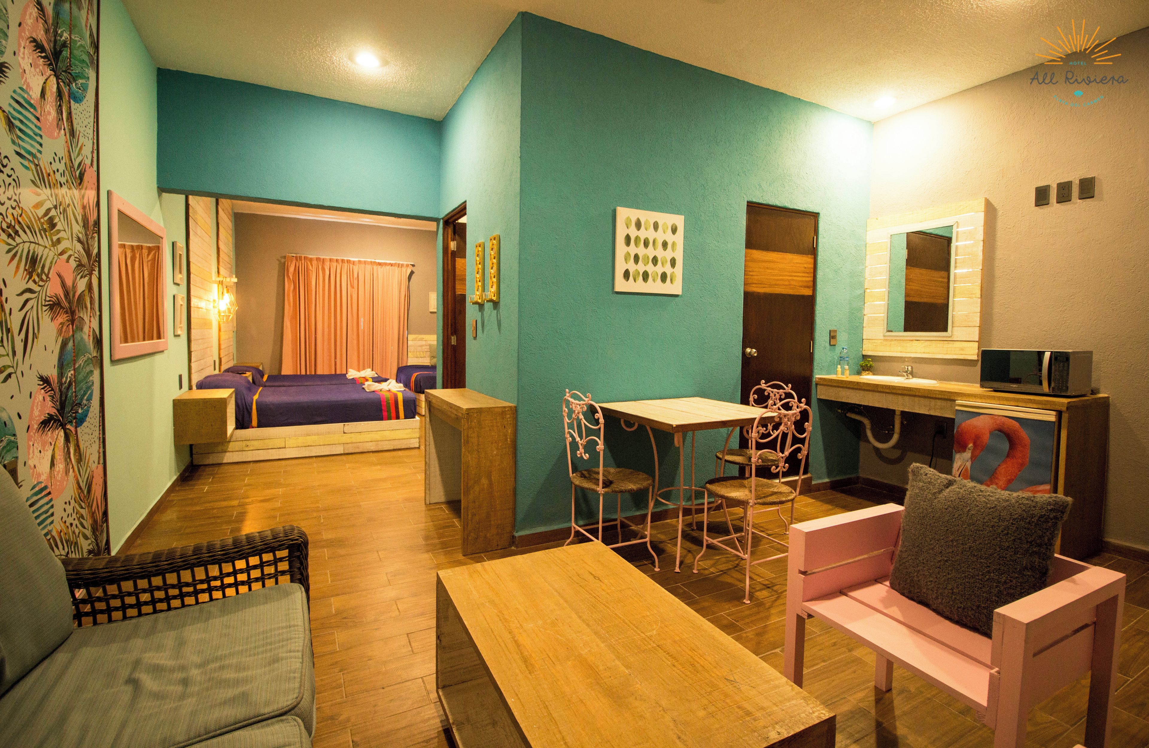 A room with a bed, a desk, a chair, a sofa, and a small table.