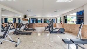 A gym with treadmills, weight machines, and a mirrored wall. - Diroma Lacqua V - Direto com o Grupo Diroma - Acesso ao Acqua Park com Café da Manhã (Caldas Novas)